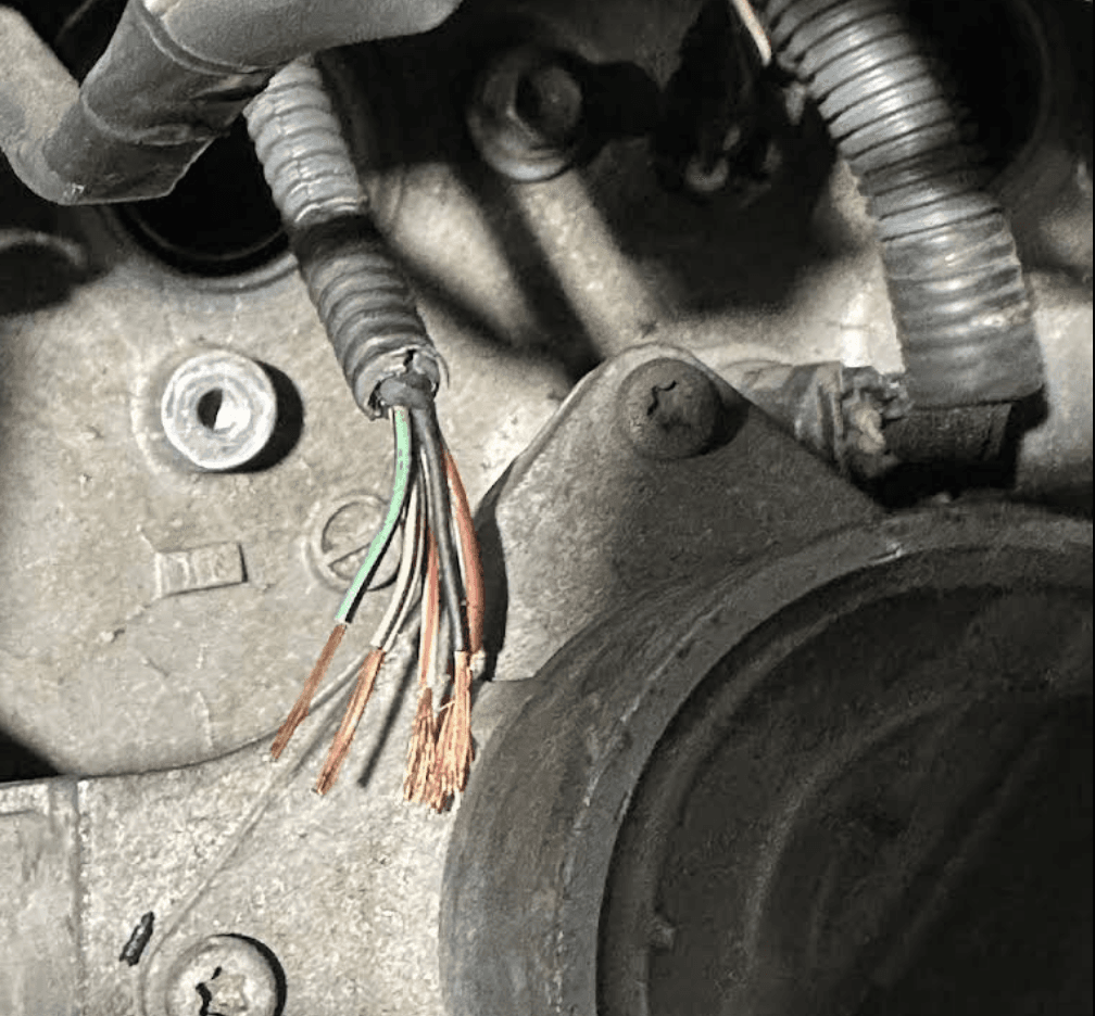 Damaged engine wiring exposed during a vehicle diagnostic inspection
