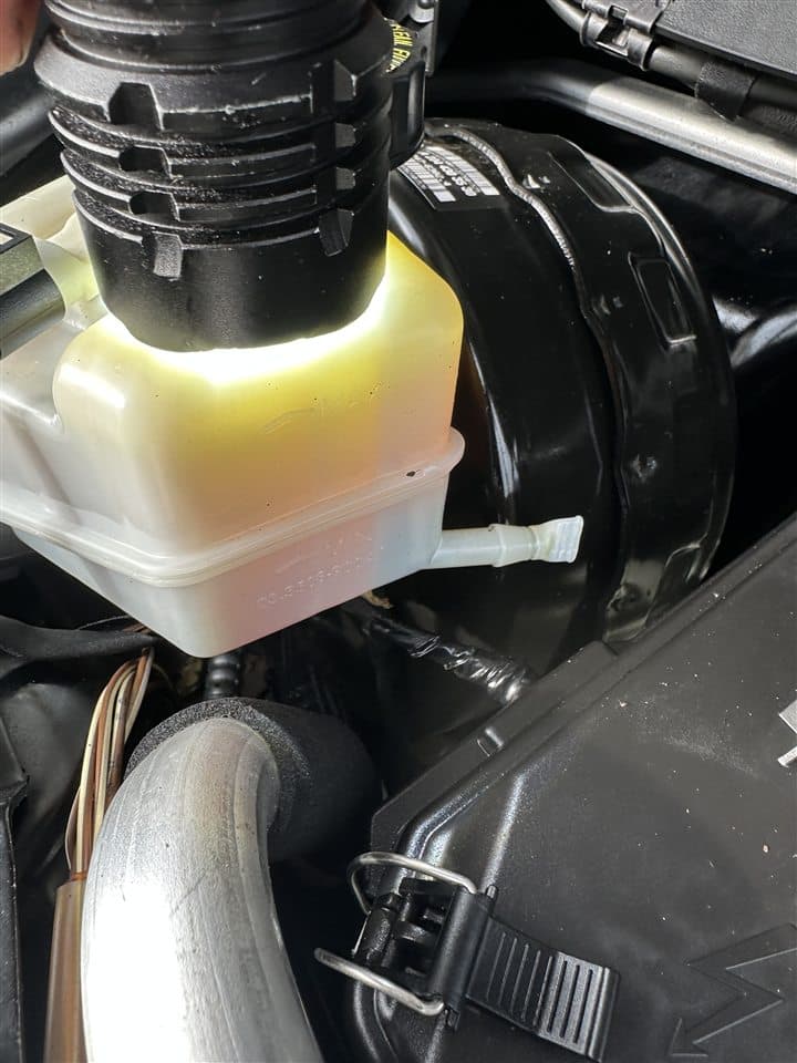 Vehicle fluid reservoir being inspected